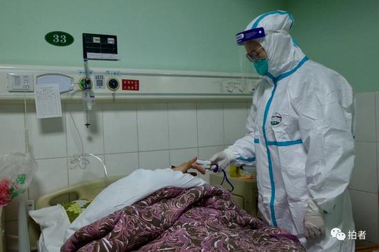 △ 1月22日，中南医院隔离区一病房内，医务人员为一新型冠状病毒患者测量体温。