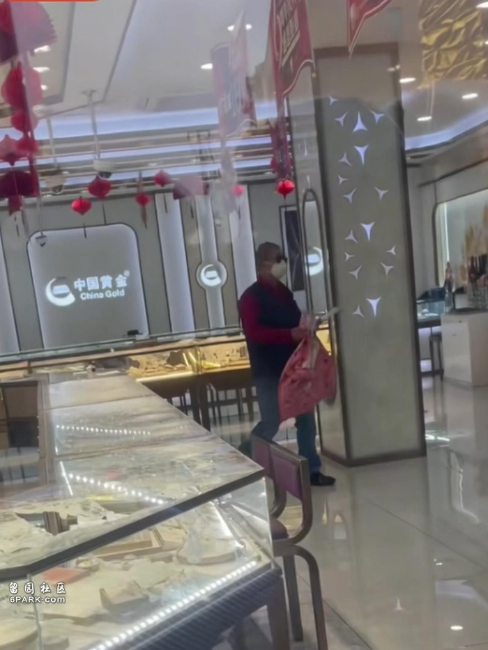 男子拿口袋抢劫上海一金店 多人在店外围观